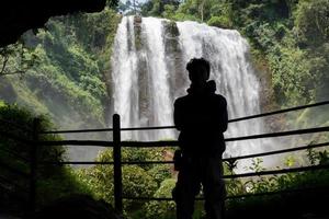 silhueta homem em a caverna dentro frente do ótimo água cair, Semarang central Java. a foto é adequado para usar para aventura conteúdo meios de comunicação, natureza poster e floresta fundo.