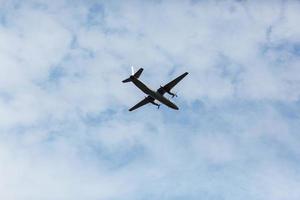uma bela vista de um avião de passageiros voador de grande porte, um avião, contra um fundo de nuvens brancas em um céu azul de verão