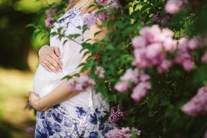 mulher grávida contra árvore em flor na primavera foto