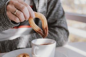 fechar-se do uma homem comendo uma típica espanhol café da manhã e churros com chocolate foto