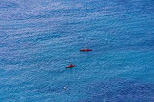 azul mar fundo com vermelho caiaques fluindo foto
