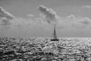 calma azul beira-mar panorama com água e céu e veleiros foto