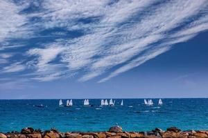 calma azul beira-mar panorama com água e céu e veleiros foto