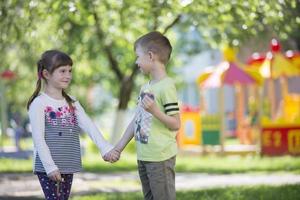 alegre crianças a partir de Jardim da infância em uma verão andar. seis ano velho Garoto e menina jogar dentro a jardim. foto