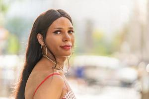 transgêneros mulher girando para Veja às a Câmera ao ar livre foto