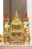ouro Buda imagem em a altar com lindo festão foto