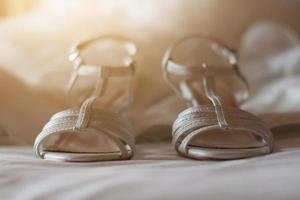 lindo branco moda Casamento sapatos em a cama com natural claro. nupcial sapatos foto