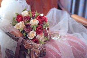 lindo rosa flores ramalhete em branco véu do noiva em vintage cadeira dentro Casamento cerimônia. namorados dia foto