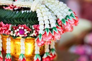 flor guirlandas em uma ouro bandeja dentro tradição tailandês Casamento cerimônia dia. jasmim festão. foto