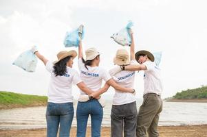 voluntários a partir de a ásia juventude comunidade usando lixo bolsas limpeza acima natureza par foto