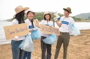 voluntários a partir de a ásia juventude comunidade usando lixo bolsas limpeza acima natureza par foto