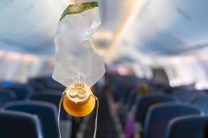 máscara de oxigênio cair do compartimento do teto no avião foto