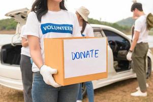 voluntários a partir de a ásia juventude comunidade usando lixo bolsas limpeza acima natureza par foto