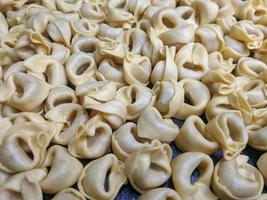 uma fechar acima topo Visão tiro do cru tortellini com branco cogumelos textura Comida fotografia foto