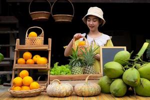 Ásia mulher vendendo uma natural variedade do frutas às a Fazenda fique foto