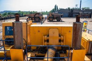 pesado amarelo aberto fundida meu despejo caminhões às reparar estação às ensolarado sem nuvens dia foto