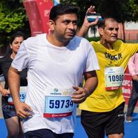 Novo Délhi, Índia - marcha 16 2023 - vedanta Délhi metade maratona raça depois de cobiçado dentro que maratona participantes sobre para Cruz a terminar linha, Délhi metade maratona 2022 foto