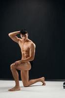 desportivo homem dentro Preto calção posando com musculoso corpo fisiculturista foto