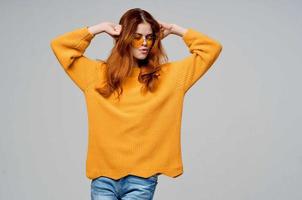 bonita mulher dentro uma amarelo suéter moda óculos estúdio modelo foto