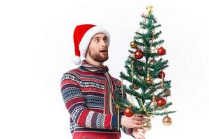 bonito homem com uma árvore dentro dele mãos enfeites feriado Diversão estúdio posando foto