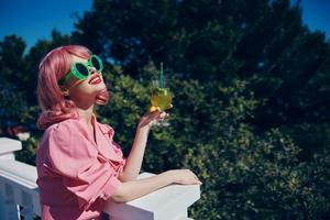 alegre mulher com Rosa cabelo verão coquetel refrescante beber bebendo álcool foto