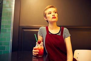 mulher com curto cabelo sentado dentro cafeteria coquetel período de férias estilo de vida foto