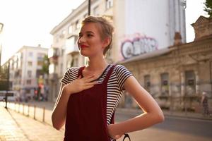 bonita mulher a partir de curto cabelo ao ar livre andar fechar-se foto