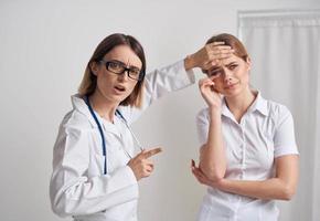 médico mulher medidas a temperatura do a paciente e uma estetoscópio em a pescoço foto