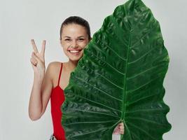 alegre mulher dentro roupa de banho verde folha mão gesto emoções foto