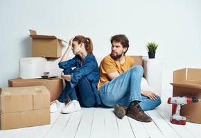 retrato do homem e mulher com caixas comovente planos para a futuro apartamento foto