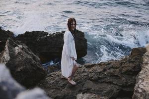 lindo mulher dentro branco vestir às a mar de praia estilo de vida inalterado foto