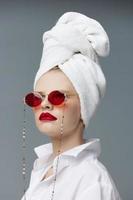 glamouroso mulher vermelho óculos toalha em cabeça Maquiagem estúdio modelo inalterado foto