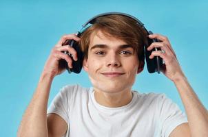 cara dentro branco camiseta vestindo fones de ouvido emoções música tecnologia azul fundo foto