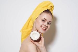 emocional mulher com nu ombros com uma coco dentro dela mãos natural cosméticos limpar \ limpo pele foto