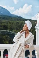 retrato mulher dentro uma branco roupão em a sacada mordeu em verde natureza perfeito ensolarado manhã foto