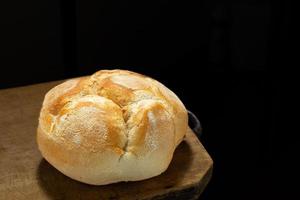 pão acabado de cozer na mesa de madeira rústica foto