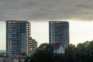 paisagem urbana com casas de árvores, edifícios altos e um céu nublado em sochi, na rússia foto