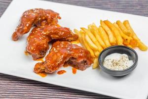 quente e picante búfalo frango asas e crocantes francês fritas com branco molho. foto