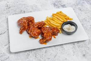 quente e picante búfalo frango asas e crocantes francês fritas com branco molho. foto