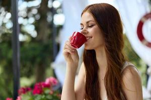 retrato do jovem lindo mulher dentro uma branco vestir bebidas café ao ar livre dentro uma cafeteria relaxamento conceito foto