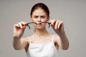 mulher óculos dentro a mãos do astigmatismo estúdio tratamento foto