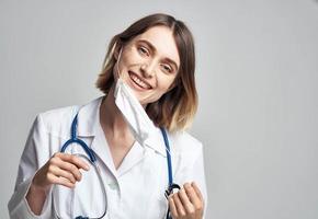 feliz mulher médico dentro médico mascarar com estetoscópio em pescoço foto