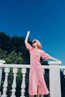 retrato do uma jovem lindo mulher com Rosa cabelo vestindo oculos de sol posando verão dia foto