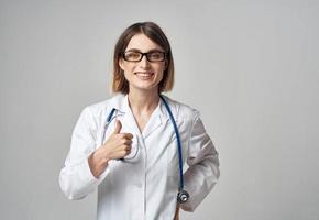mulher médico com estetoscópio gesticulando com mãos emoções óculos modelo foto