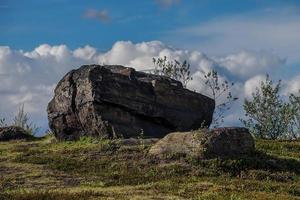 grande rocha em um campo verde na Rússia foto