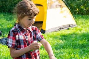 menina pulveriza spray de mosquito na pele na natureza que morde as mãos e os pés. proteção contra picadas de insetos, repelente seguro para crianças. recreação ao ar livre, contra alergias. horário de verão foto