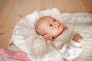 menino bonito em um bebê recém-nascido de quarto de luz branca é fofo. na roupa de cama para crianças nascidas - imagens foto