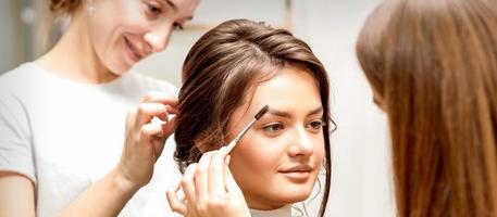 Maquiagem artista pentear sobrancelhas e estilista de cabelo preparando Penteado foto