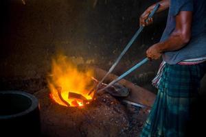 inseguro trabalhador mãos. uma local aço máquina partes fazer Jardim trabalhador Derretendo sucatear em quente forno. foto