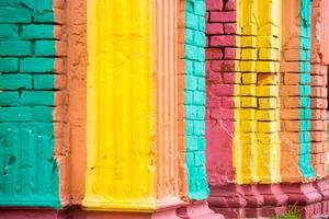 vermelho, laranja, amarelo e azul cor combinação velho texturizado danificar parede com colorida tijolos. foto